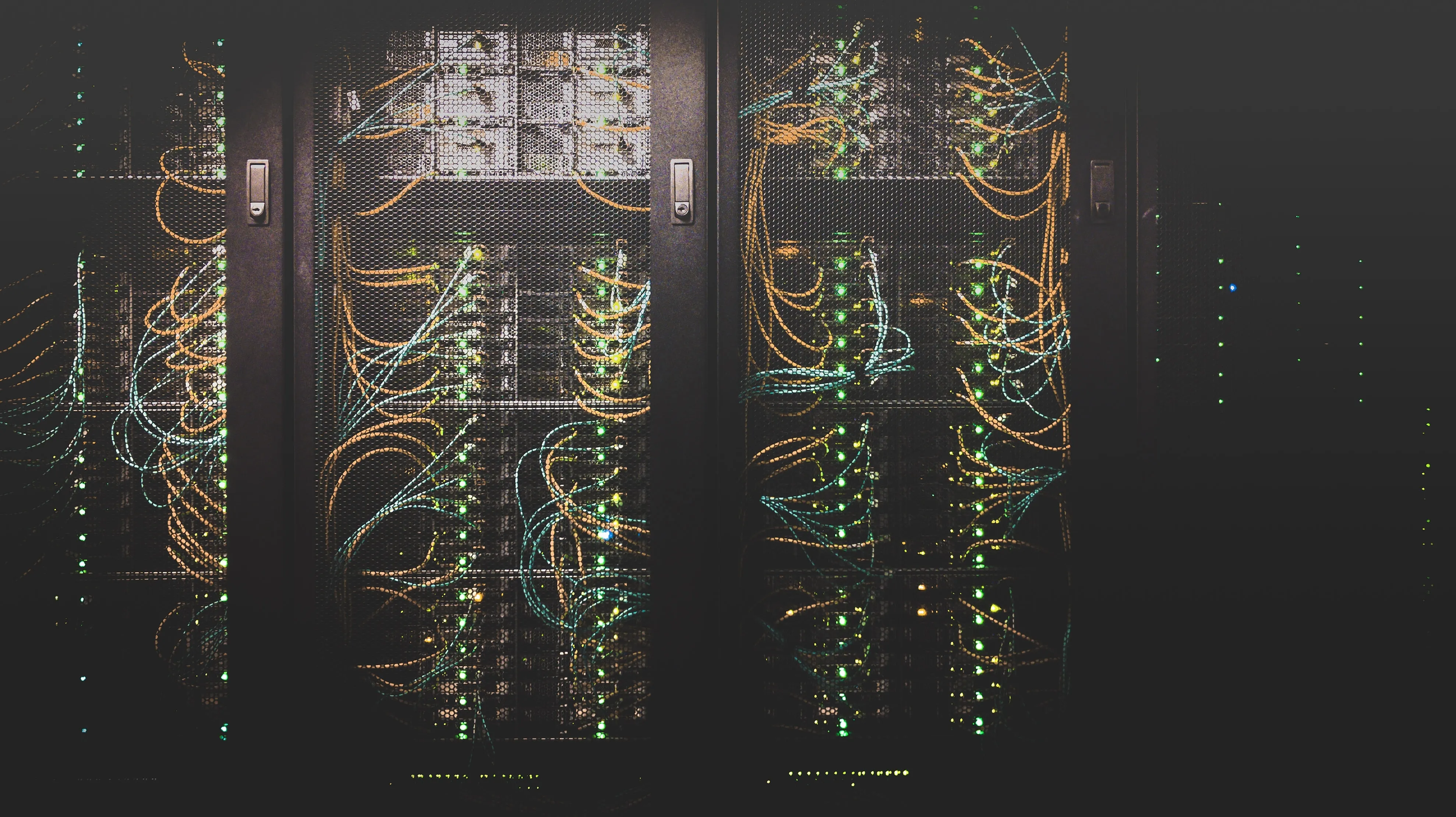 Server racks filled with networking equipment connected by patch cables.